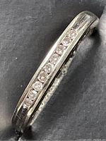 Close-up image showing the front view of the white gold ring with diamonds set in a channel.