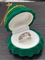 Ring displayed inside a green velvet star-shaped box with white interior, showing the overall look and setting of the ring.