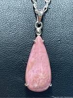 Close-up front view of the pink teardrop gemstone pendant on sterling silver chain, showing color and setting details