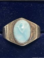 Front view of the sterling silver ring with an oval larimar stone, showing blue and white marbling.