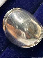 Close-up front view of the polished sterling silver ring showing dome shaped top and wear scratches.