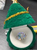 Ring displayed in green velvet ring box shaped like a Christmas tree.
