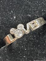 Close-up photo showing the sterling silver ring with 'LOVE' design and clear stones in 'O' and 'V'.