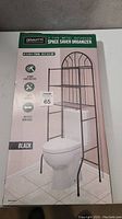Photo of the Gravitti 3-tier black metal bathroom space saver organizer box showing dimensions, features, and image of product over toilet.