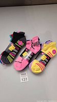 Three packs of brand new women's athletic ankle socks in different colors and patterns