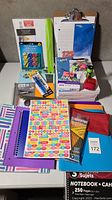 Full overview of school supplies showing notebooks, writing pads, erasers, clipboard, and stationery items