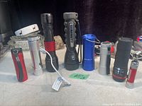 Photo showing all eight flashlights in different sizes, colors, and designs arranged in a row.