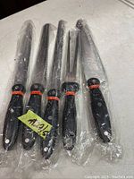 Five Carl Weill cutting tools laid out on a white surface, each wrapped in clear plastic.