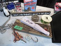 Photo showing ceramic penguin figurine, 'Skin Art Bandage Assortment' tin, Mandarin Chinese DVD set, folding hand fan, trinket box, coin bank, multiple wall hooks, violin figurine, and decorative plaque