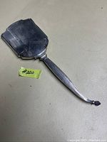 Full view of the hand mirror showing the slightly worn handle and silver frame with normal age wear.