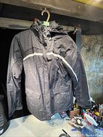 Front view of the Columbia Sport jacket hung on a hanger, showing full length, zipper, hood, and pocket details.