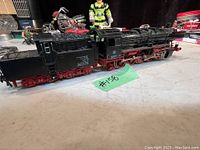 Side view of the black and red Fleischmann steam locomotive with tender showing the detailed body and wheels.