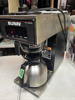 Front and angled view of Bunn VP-17 stainless steel coffee maker with thermal carafe on a table.