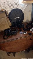 Overview showing camera body, multiple lenses, backpack, reflector and filter cases.