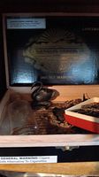 Vintage Silverado Double Maduro cigar box with silver swan figurine, glass jar, and a red and white box containing small items.
