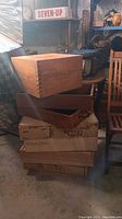 Stack of wooden wine crates in a workshop or storage area, showing branded logos and text