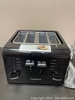 Front view of black toaster showing control buttons and levers for 4 slices