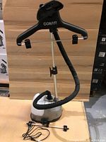 Complete Conair fabric steamer unit standing assembled with 360-degree hanger, steam hose, clips, and power cord visible.
