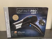 Front view of the Conair Infiniti Pro hair dryer box showing model and wattage information plus styling attachments included.