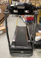 Front view of treadmill showing black running belt with orange trim and handrails.