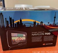 Box front showing product name Navigon 7100 with city skyline background and image of GPS display