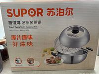 Photo of the Supor multi-purpose pot packaging box showing the product image and brand name in English and Chinese, highlighting the steaming function and 2.5 liter capacity.