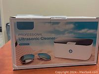 Box for VPCOK Professional Ultrasonic Cleaner, model SU-779, showing product image with sunglasses as example of use.