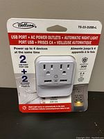 Front view of Wellson TS-23-2USB+L packaging showing 2 USB ports and 2 AC power outlets with automatic night light information.