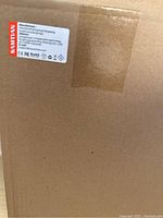 Close-up of cardboard box with SanTian manufacturer label showing brand and certifications