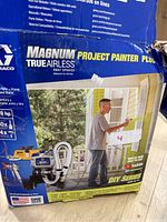 Box with product label showing Graco Magnum Project Painter Plus TrueAirless paint sprayer packaging with image of product and specifications.