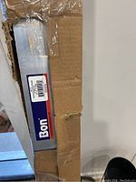 Side view of cardboard packaging showing BON brand label and part of screed tool inside box.