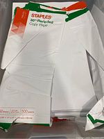 Partially opened reams of Staples 30% recycled copy paper showing packaging details and condition