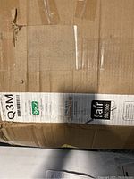 Photo of the packaging box side with label showing Q3M model, Fair for Life certification, and OEKO-TEX Standard 100 branding.