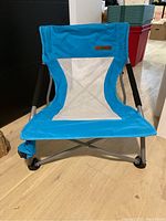 Front view of one blue sand beach chair showing fabric seat, mesh back, padded armrests and metal frame.