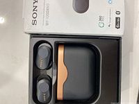 Sony WF-1000XM3 earbuds in charging case with original packaging visible.