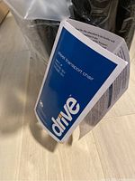 Close-up of product manual label showing the product name 'Steel transport chair' and model TR37E-SV by Drive.