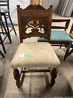 Front view showing carved oak backrest and upholstered seat with floral pattern