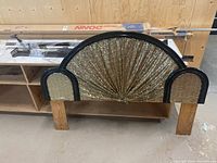 Front angled view of the headboard showing wood frame, fabric inserts, and legs.