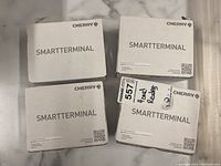 Four boxed Cherry Smart Terminal ST-1144 card readers seen from the box top.