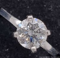 Close-up of ring showing 1 carat round brilliant diamond in six-prong setting on white gold band