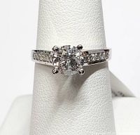 Front view of ring showing solitaire diamond and accent stones