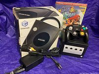 Overall lot with console in original box, controller, power adapter, AV cable and strategy guide
