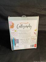 Front of box showing 'ArtMaker Calligraphy' with floral design, starter kit contents listed