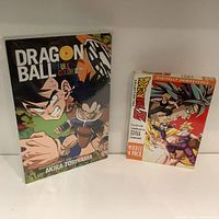 Front view of Dragon Ball Full Color Edition book next to Dragon Ball Z Movie 4 Pack DVD set