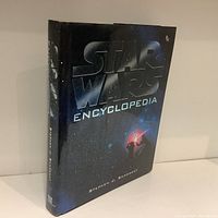 Front angled view of the Star Wars Encyclopedia book showing spine and front cover with space background and title.