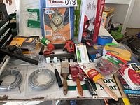 Overview of lot showing painting supplies, dog tie outs, stapler, tarp, fuel transfer pump, and assorted hardware.