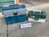Both fishing tackle boxes side by side on the ground, showing relative size and condition.