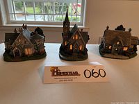 Three lighted village buildings displayed together showing overall set condition and lighting.