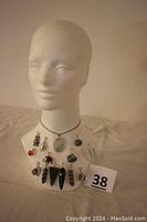 Mannequin bust displaying all 15 pendants arranged around the neck and base with the sterling silver chain at the top.