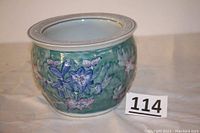 Blue and white ceramic planter with floral motif and wide rim with geometric pattern.